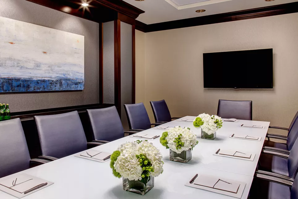 Amway Grand_Meeting Room_Setup_Long Table_Chairs_Notespads_Pens_Flowers_Water Bottles_Painting_TV