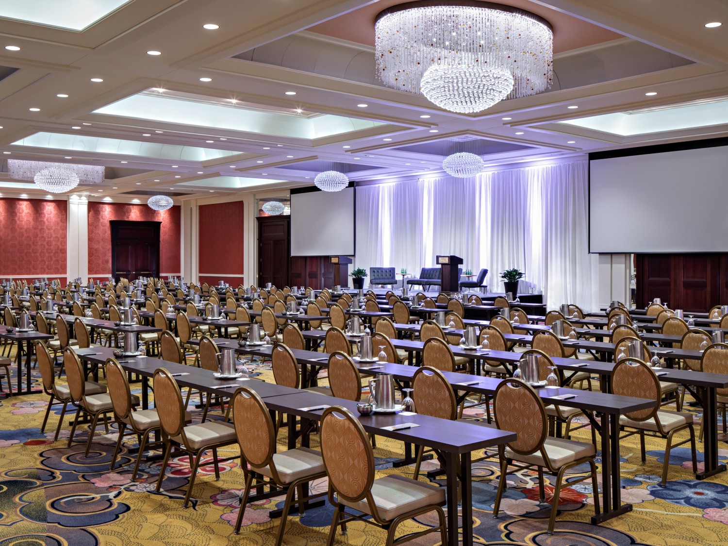 Amway Grand_Ambassador Ballroom_Set Up_Long Tables_Chairs_Note Pads_Pens_Chandelier_Screen Projectors