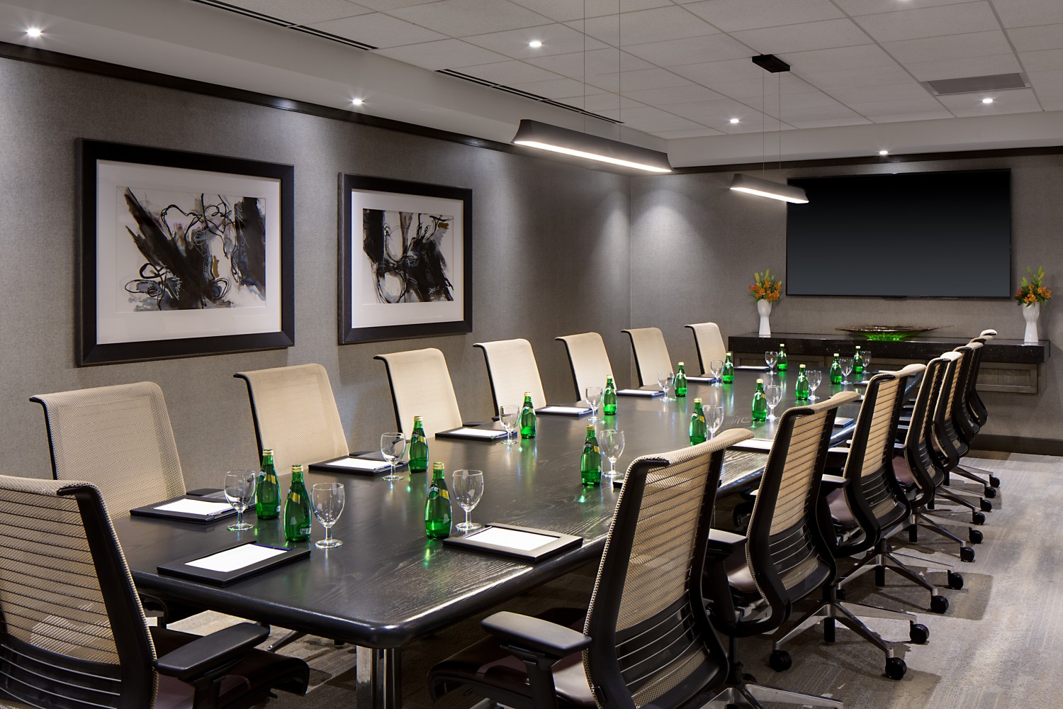 Amway Grand_Fine Arts Meeting Room_Meeting Room_Set Up_Long Table_Chairs_Notepads_Pens_Water Bottles_Paintings_TV_Flowers