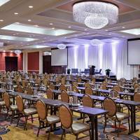 Amway Grand_Ambassador Ballroom_Ballroom_Meeting Room_Event Space_Set Up_Rows of Tables_Chairs_Projector Screens_Chandeliers_Notepads_Pens_Stage_Podium