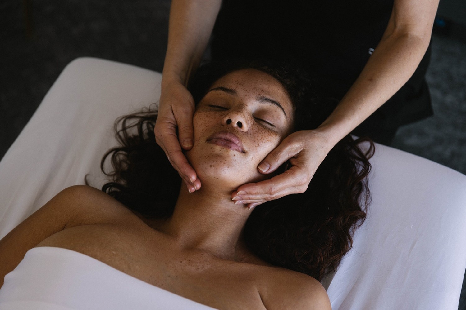 Amway Grand_Celeste Salon & Spa_Facial_Woman Laying Down_Service Provider Rubbing Woman's Face