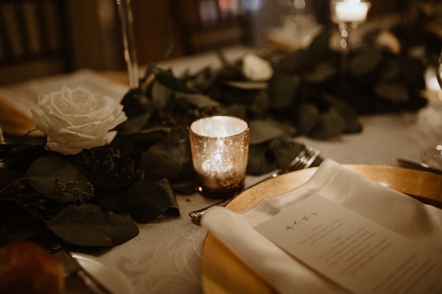 Amway Grand_Wedding Set Up Detail Shot__Dark_Candles_White Roses_Greenery_Plates_Menus_Napkins